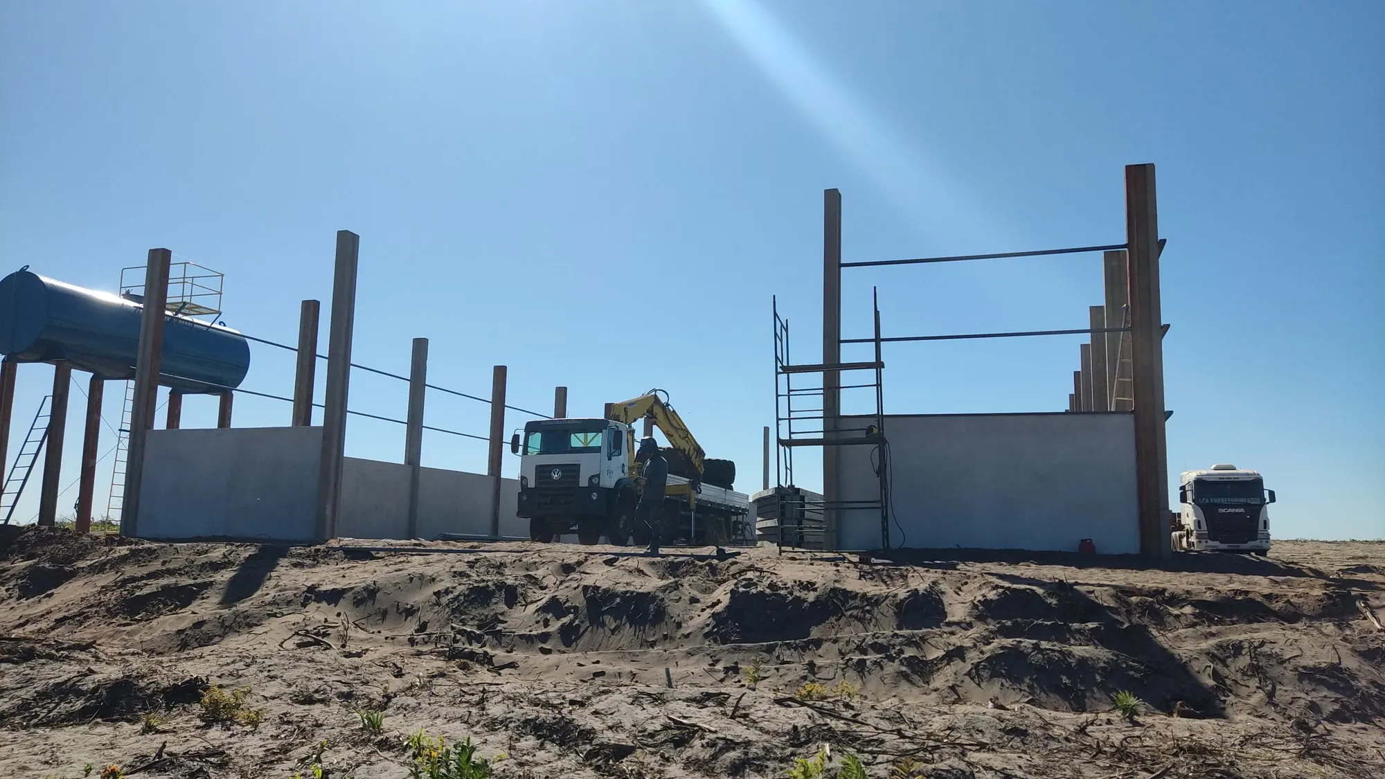 Canteiro de obra com caminhão munck e colunas prontas para receber a estrutura metálica — MR Serralheria