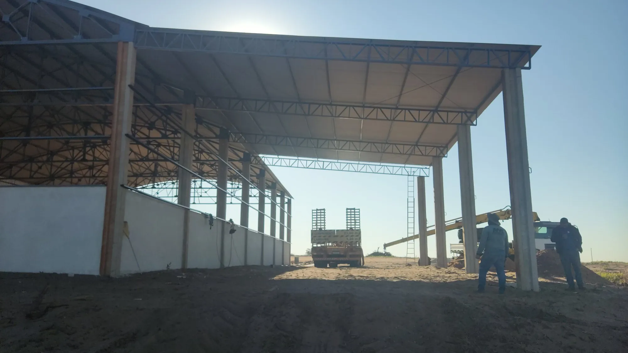 Interior de galpão com cobertura metálica montada e equipe finalizando a estrutura — Norte do Paraná