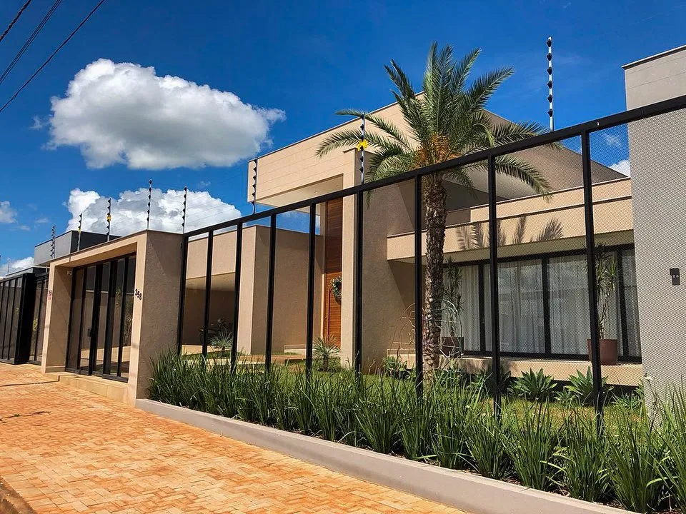 Fachada residencial moderna com gradil e portões metálicos pretos fabricados pela MR Serralheria