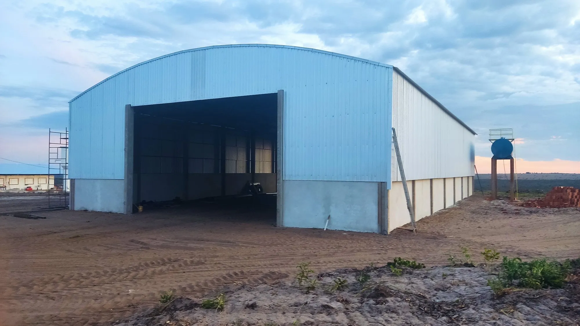 Vista lateral de galpão metálico com fechamento em telha galvanizada concluído — estrutura metálica PR
