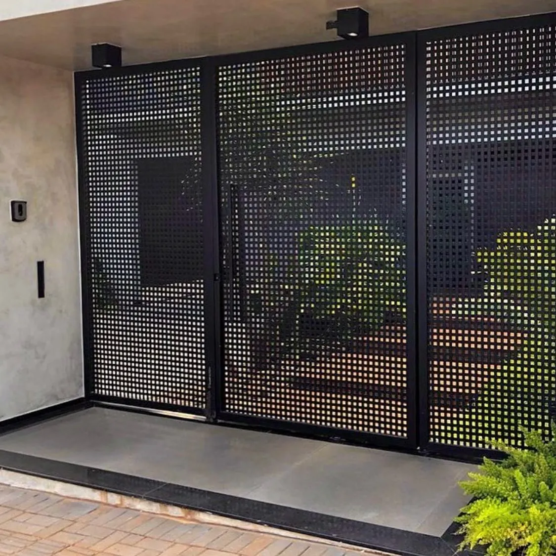 Portão pivotante em chapa perfurada preta com iluminação de entrada — MR Serralheria, Sertanópolis-PR